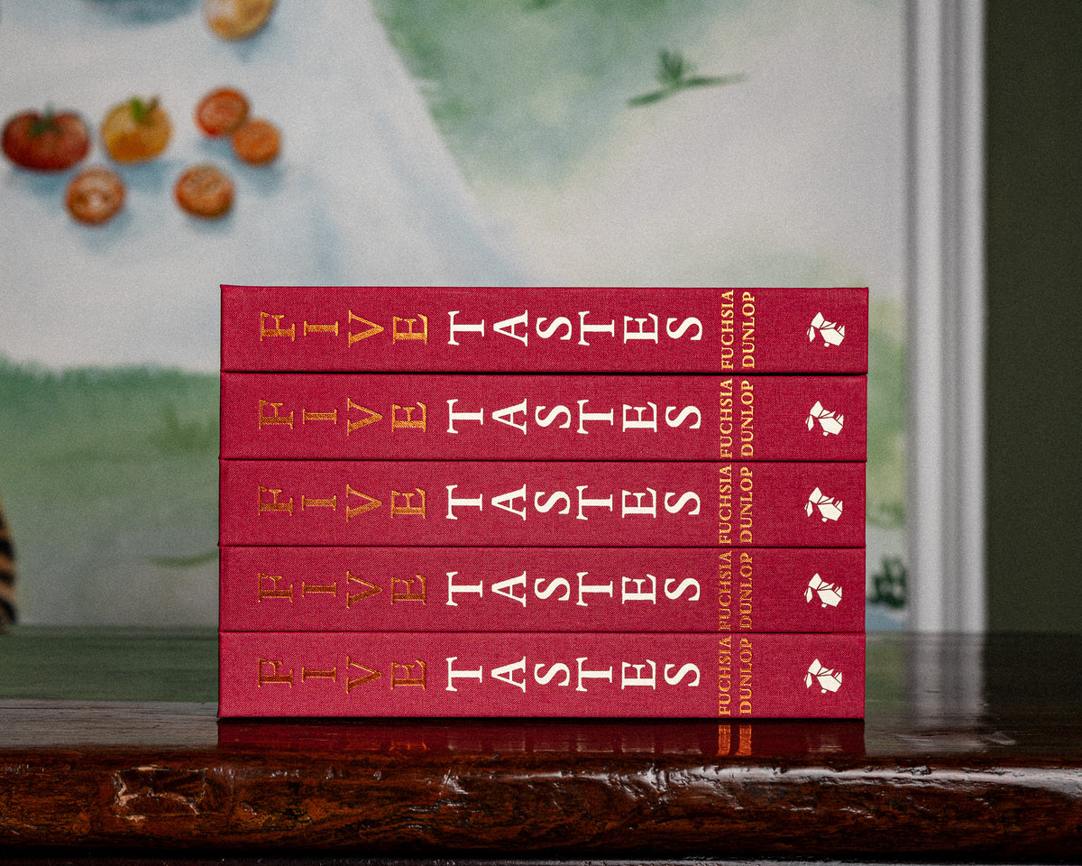 Five copies of Five Tastes by Fuchsia Dunlop stacked with their red spines facing out